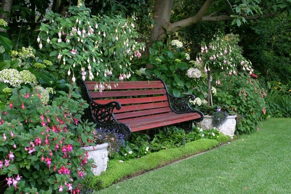Белая Резная скамейка в саду на зеленом фоне